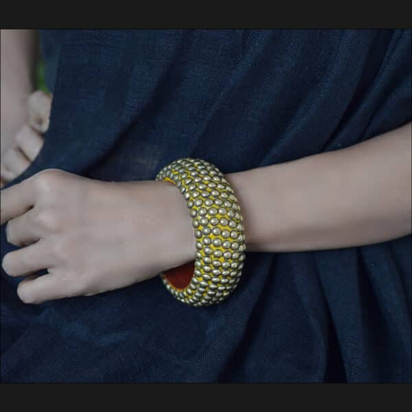 Wooden bangle with brass repousse