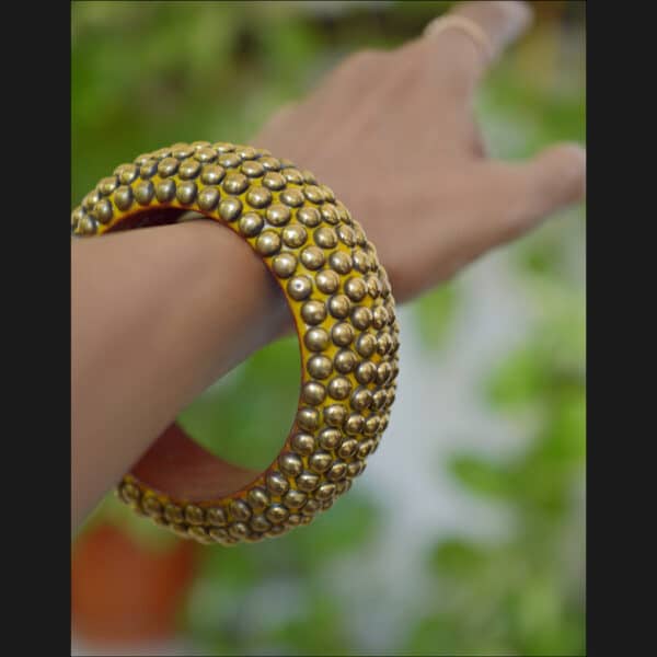 Wooden bangle with brass repousse